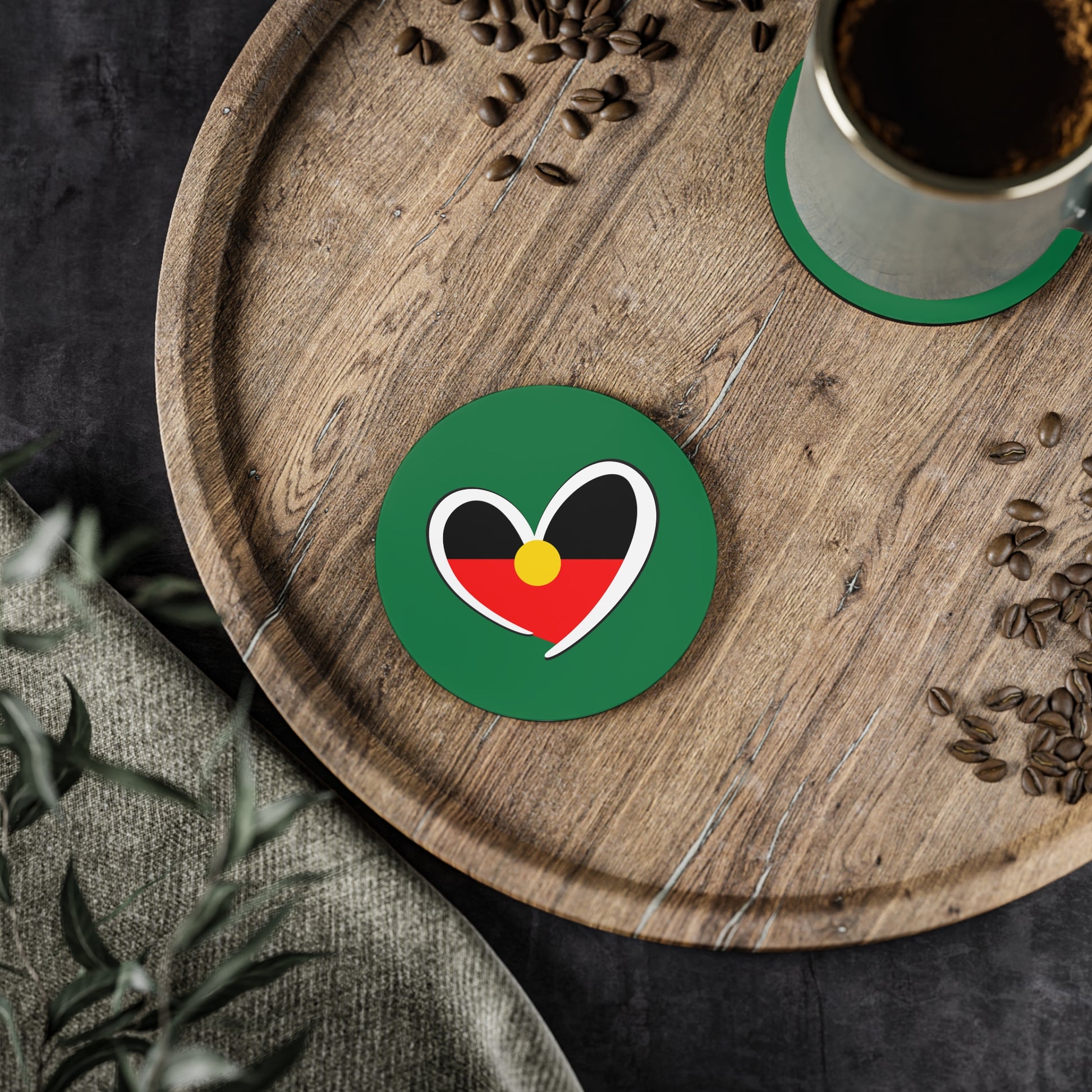 Green circle Aboriginal coaster with heart design in a home setting