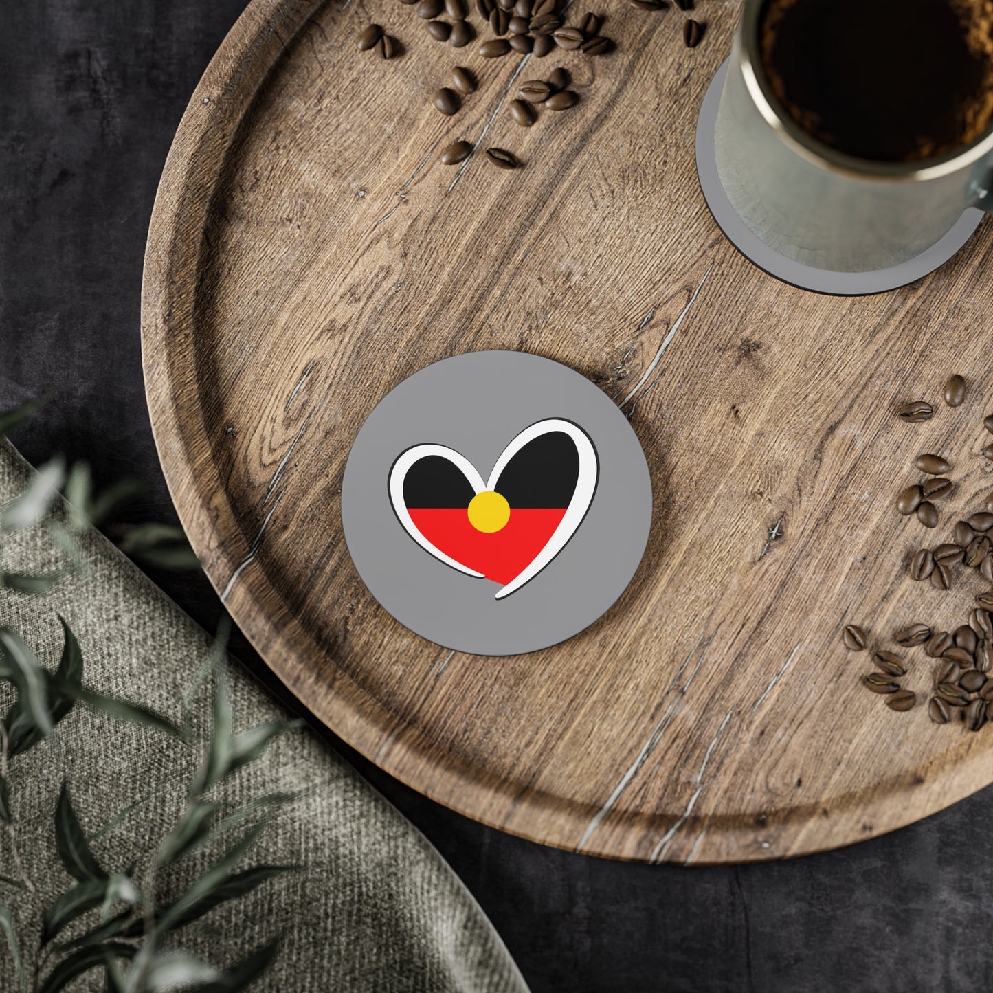 Aboriginal heart coaster on timber tray with coffee beans, adding cultural warmth to your space.