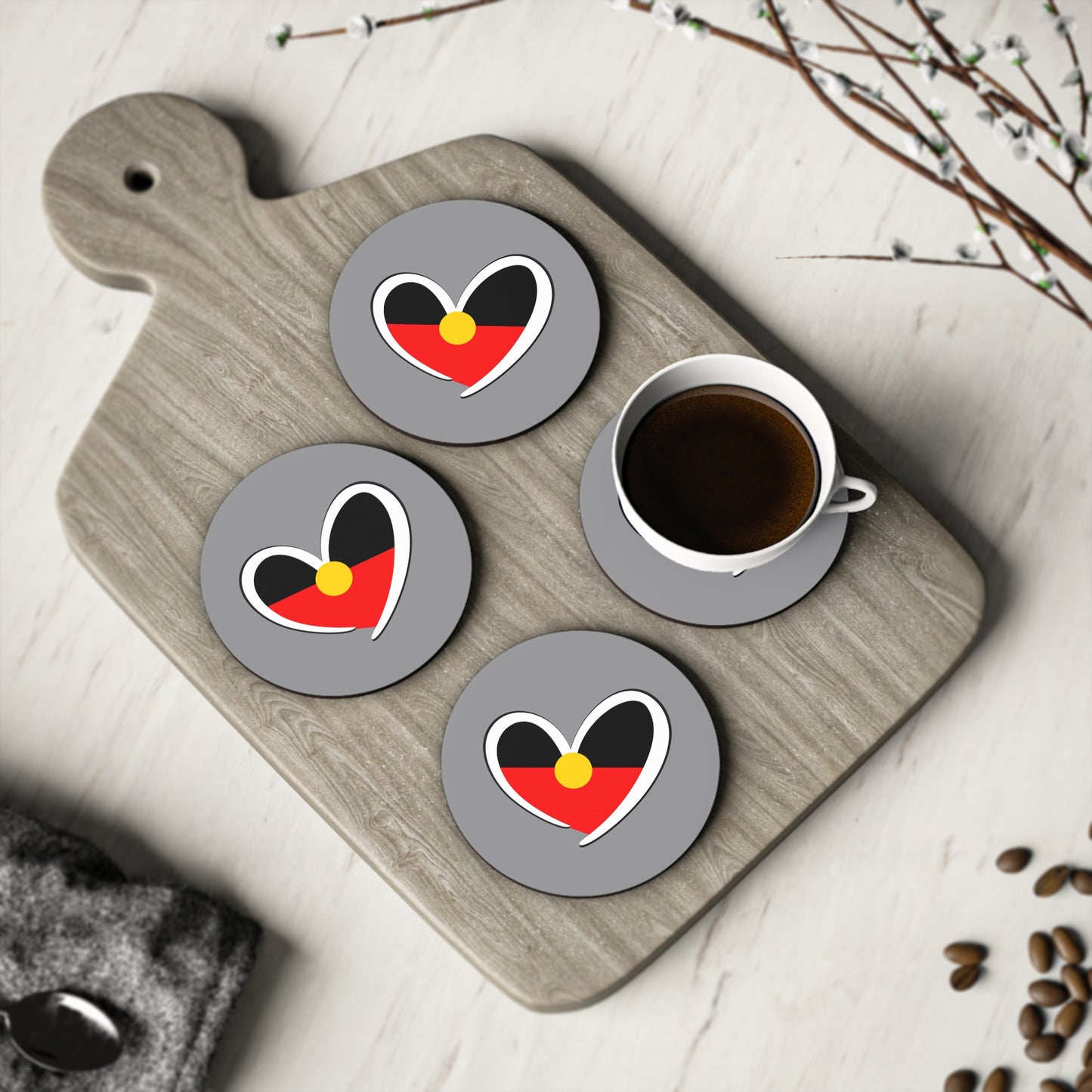 Set of round Aboriginal heart coasters displayed with coffee, celebrating culture and unity.