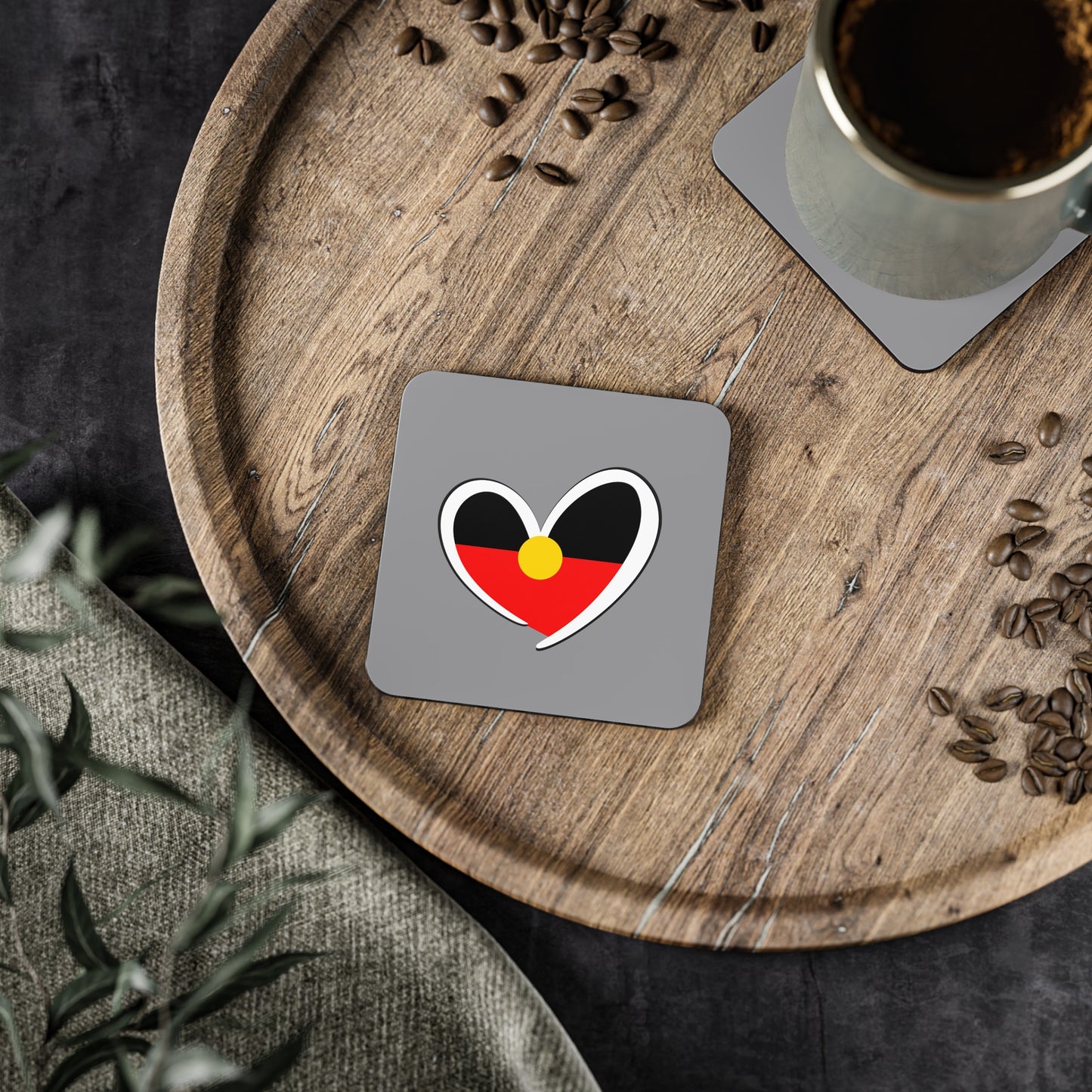 Square Aboriginal heart coaster on timber tray, blending culture with daily rituals.