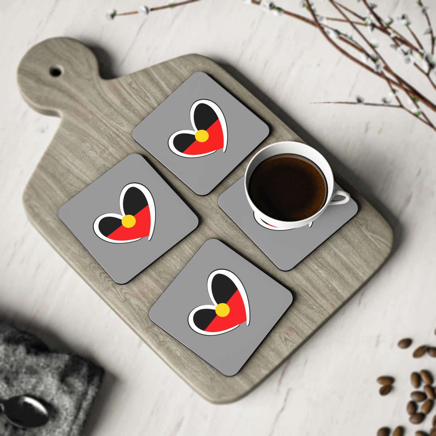 Set of four Aboriginal heart square coasters styled on timber board for cultural elegance.