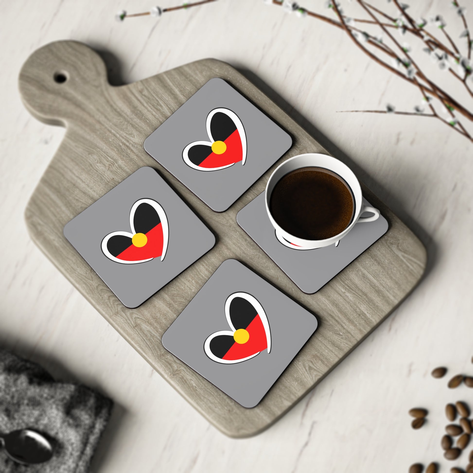Set of four Aboriginal heart square coasters styled on timber board for cultural elegance.