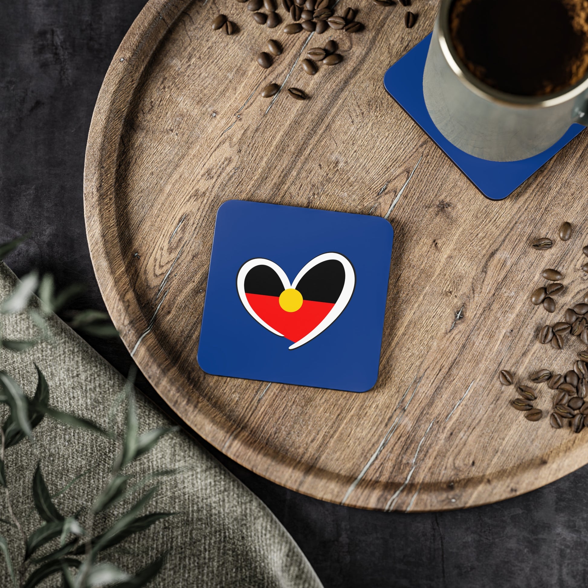 Square Aboriginal heart coaster on timber tray, blending culture with daily rituals.