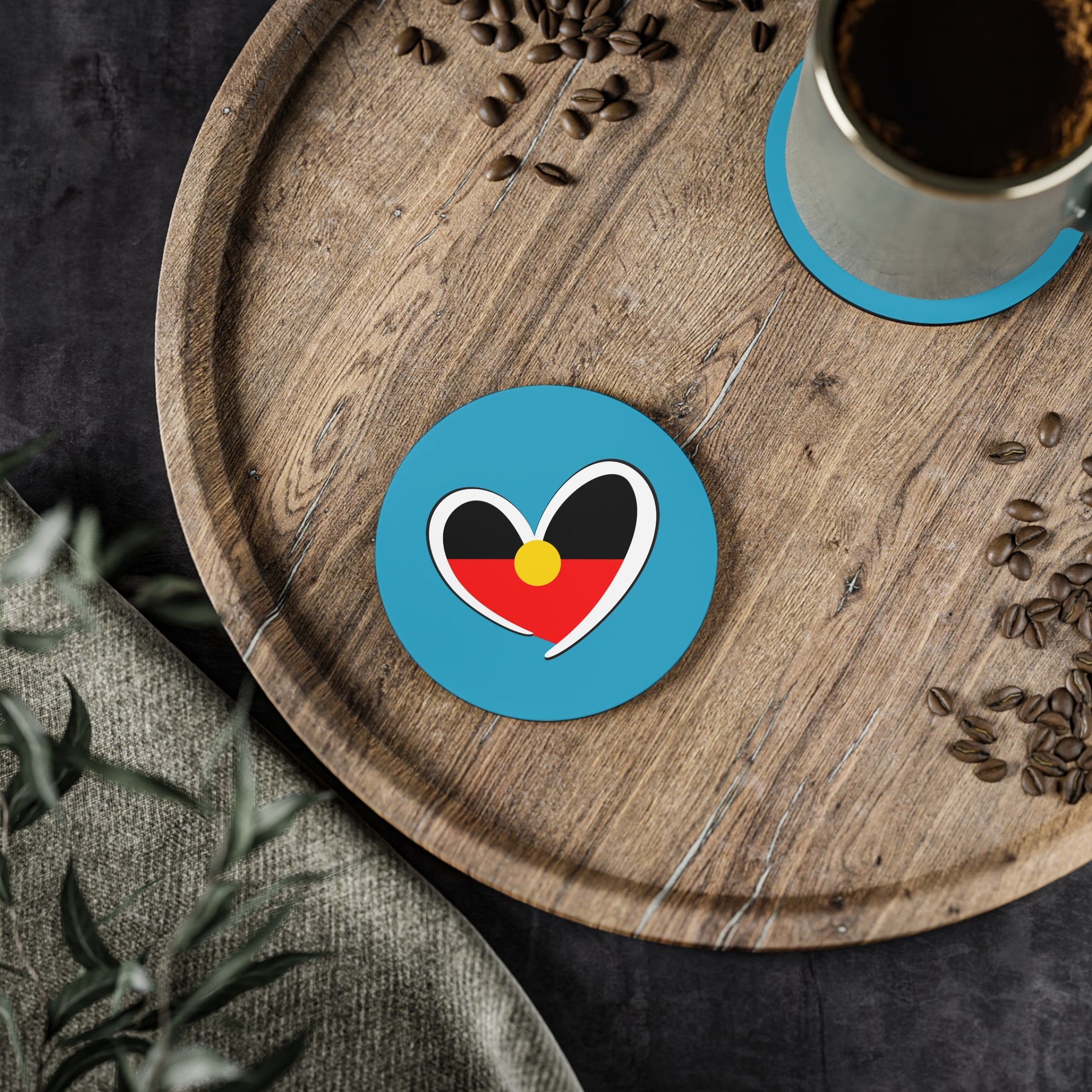 Turquoise circle Aboriginal coaster with heart design in a home setting.