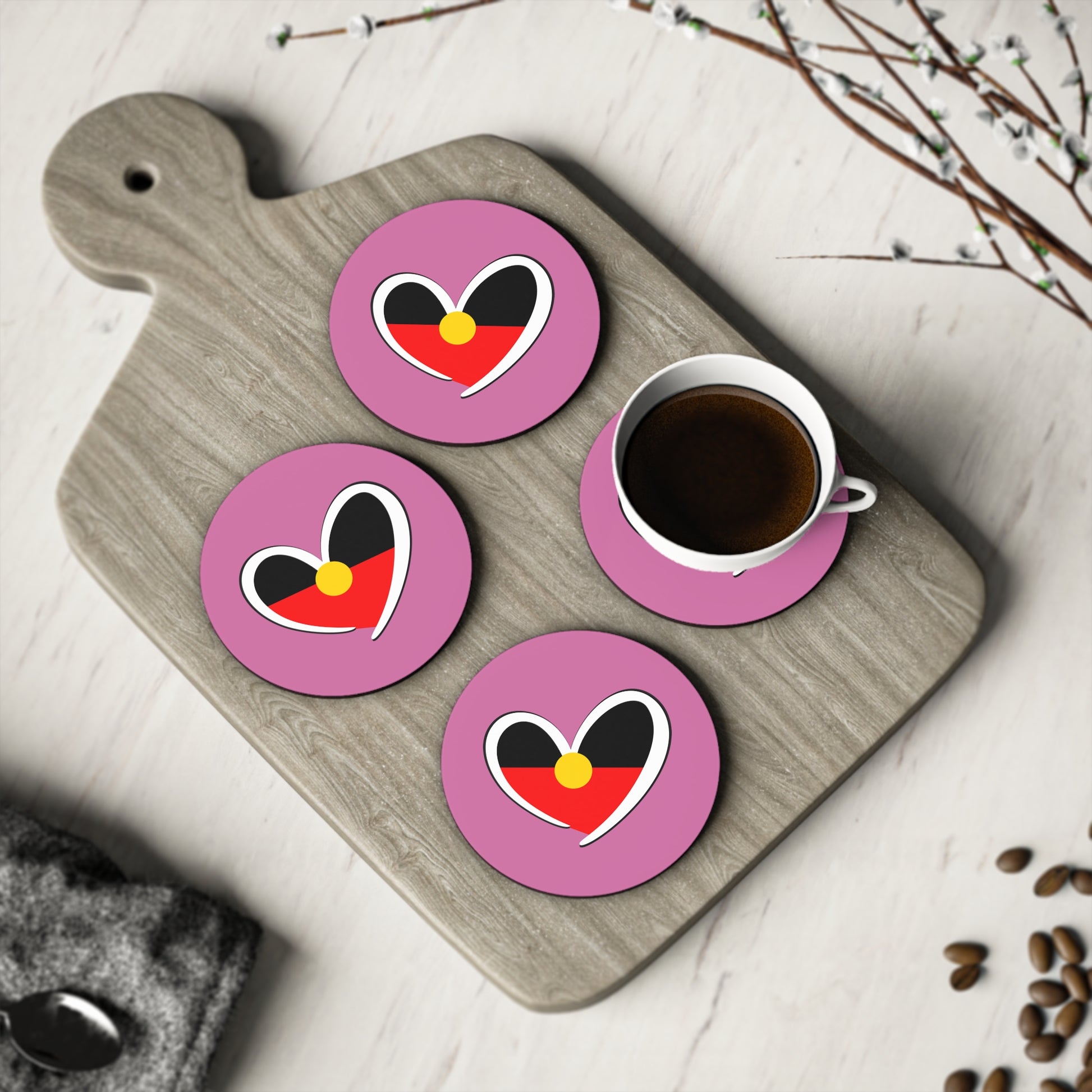 Set of 4 pink round Aboriginal coasters arranged with cup on serving board – cultural tabletop design.